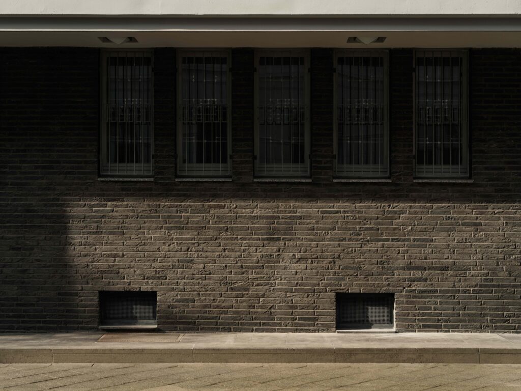 Exterior facade of the Otto Church showing dark brickwork and narrow vertical windows with security grilles.