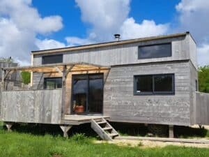 Tiny XXL house exterior showing natural wooden facade and sustainable small home design in a semi-stationary layout.