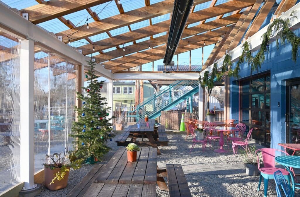 Big Roof architectural project in Detroit combines flexible open-air spaces, seasonal dining areas, wavy roof design, transparent structure, and natural environmental integration.