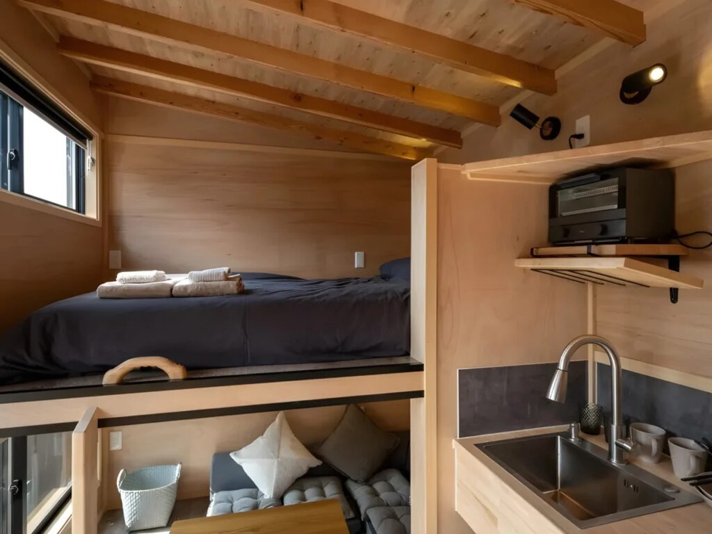 Yamabiko compact house by Ikigai Collective in Nozawa Onsen, illustrating innovative small-space living with symmetrical design, efficient interiors, elevated bedrooms, and integrated kitchen and bathroom.