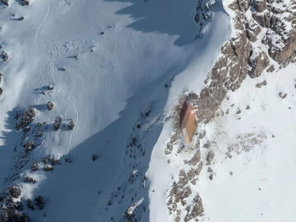 Exterior view of the CRA mountain shelter integrating circular design with the natural Alpine landscape.