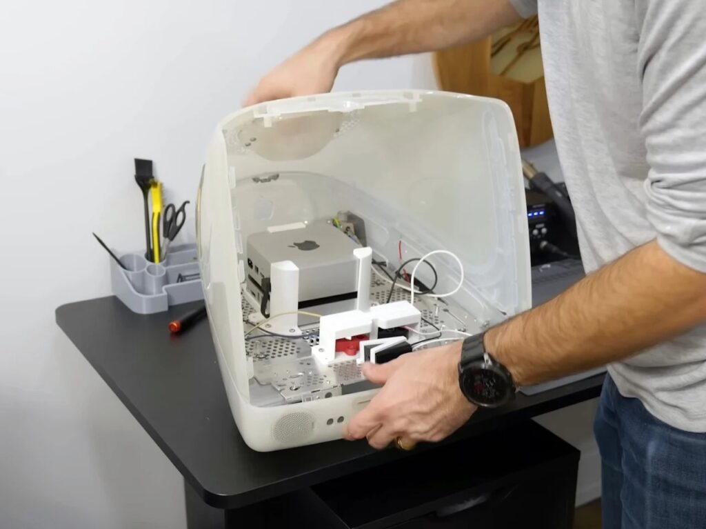 Refurbished Apple iMac G3 featuring original translucent design with modern Mac Mini integration, 4K OLED display, upgraded storage, and enhanced audio system, blending 1990s aesthetics with contemporary performance.