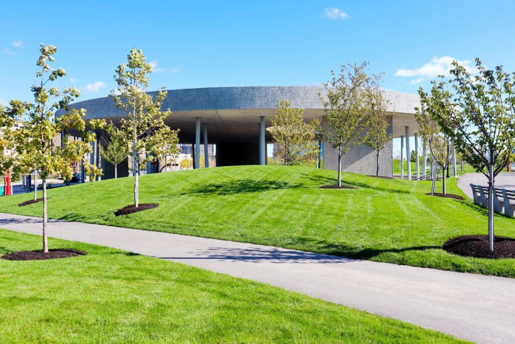 Overview of Ralph C. Wilson Jr. Centennial Park showing green spaces, pathways, and riverfront interaction in Detroit.