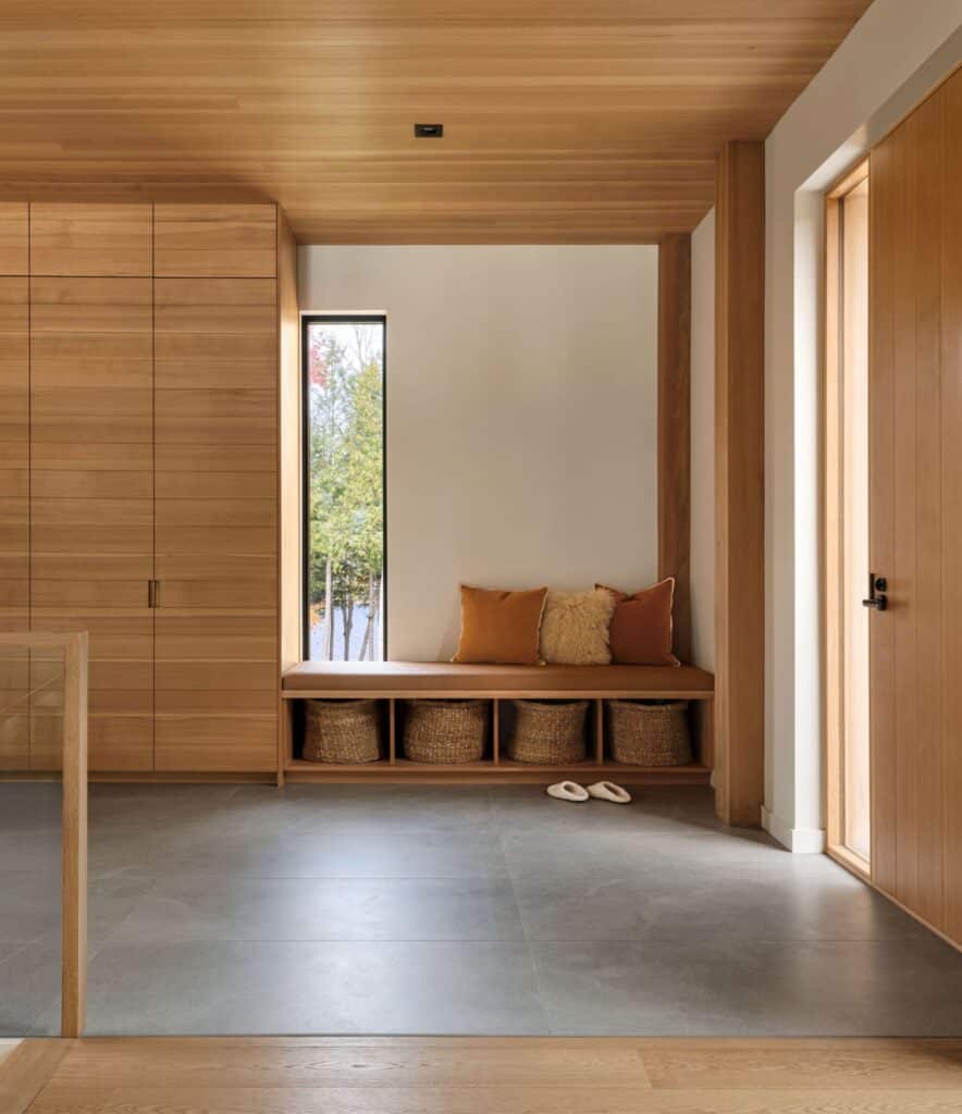 Long Lake Cabin showcases a sustainable architectural design that blends natural wood materials with the surrounding forest while offering elevated spaces and panoramic views connected seamlessly to the landscape.