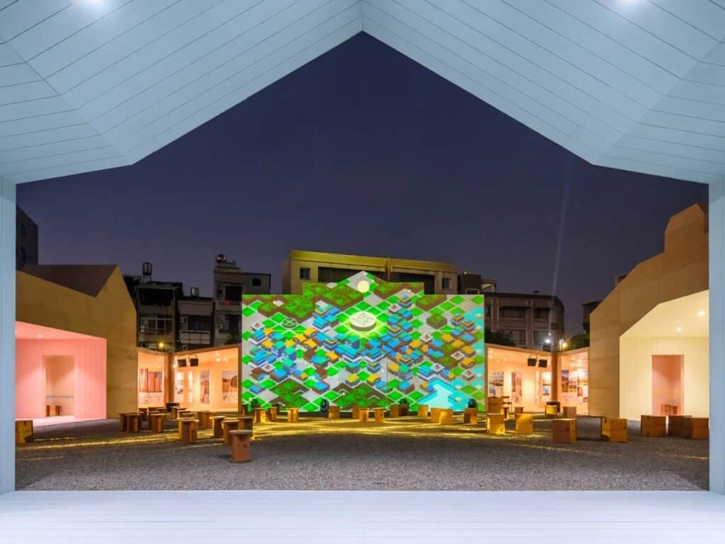 Night view of Wood Wonders Pavilion featuring a large digital projection on a timber wall reflecting urban patterns.