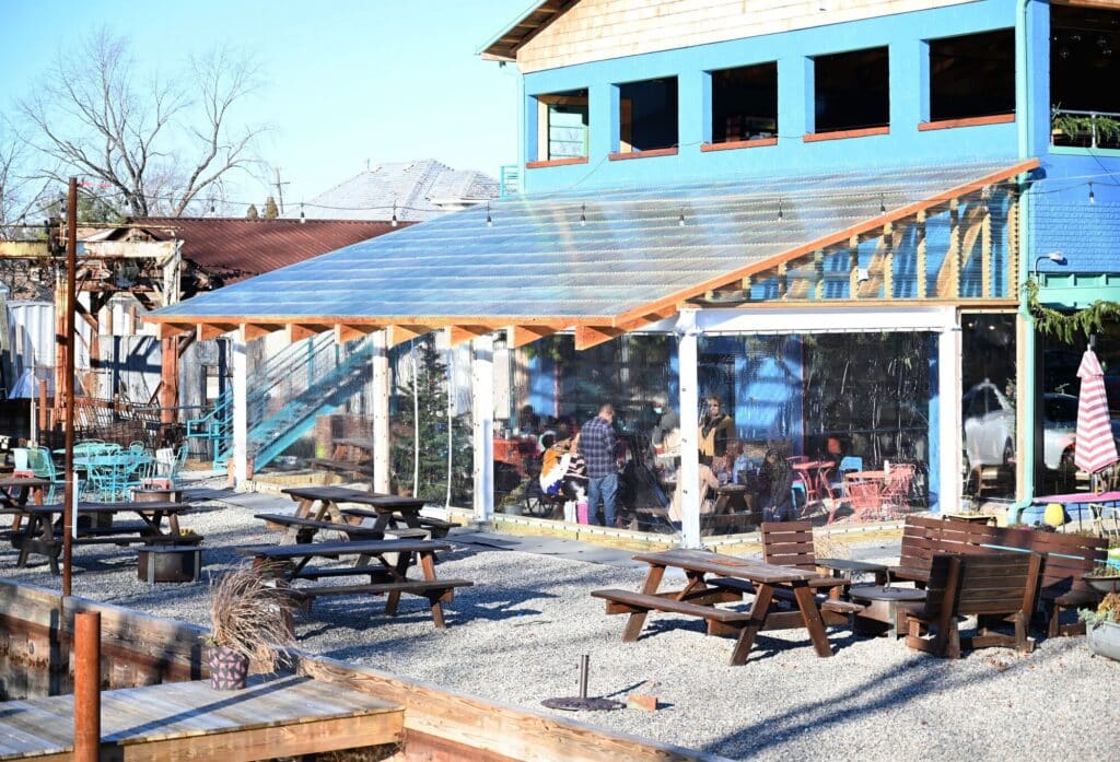 Big Roof architectural project in Detroit combines flexible open-air spaces, seasonal dining areas, wavy roof design, transparent structure, and natural environmental integration.