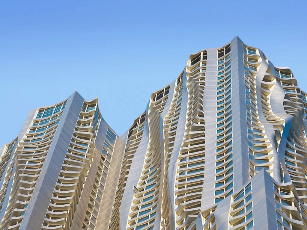 8 Spruce Street skyscraper in New York by Frank Gehry with rippled stainless steel facade creating dynamic urban movement.