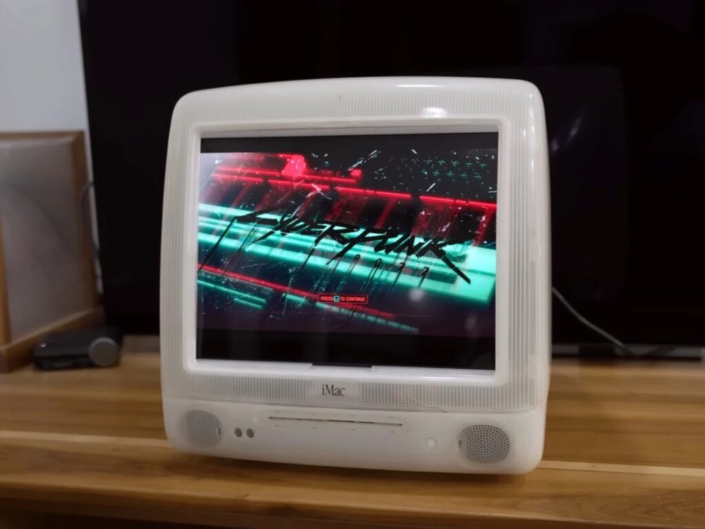 Refurbished Apple iMac G3 featuring original translucent design with modern Mac Mini integration, 4K OLED display, upgraded storage, and enhanced audio system, blending 1990s aesthetics with contemporary performance.