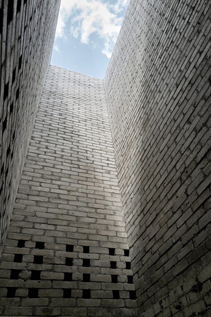 Swiss Brick Museum showcasing traditional manual brick-making, innovative pre-stressed earthen tower, exhibition spaces, and sustainable building techniques for architectural research.