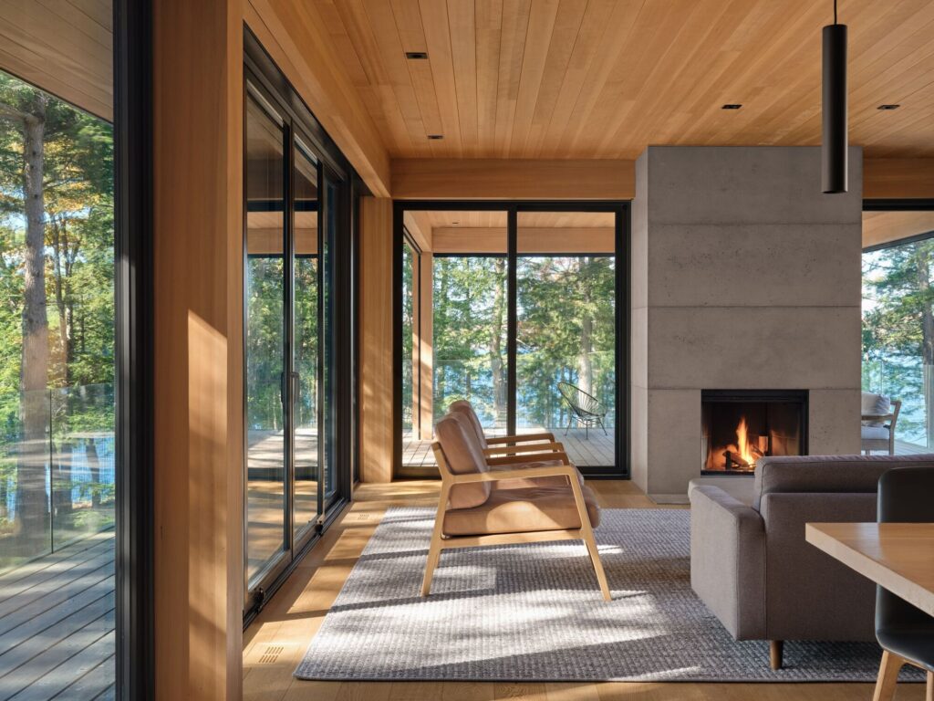 Long Lake Cabin showcases a sustainable architectural design that blends natural wood materials with the surrounding forest while offering elevated spaces and panoramic views connected seamlessly to the landscape.