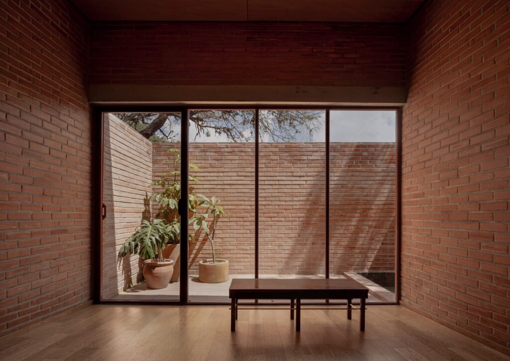 Peroles House in San Miguel de Allende integrates steep terrain, diverse local vegetation, traditional urban planning, and brick construction, showcasing sustainable residential architecture and careful spatial organization.