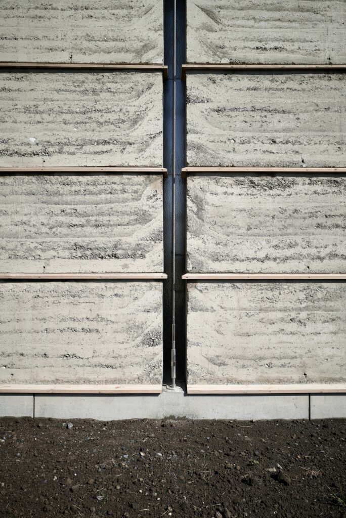 Swiss Brick Museum showcasing traditional manual brick-making, innovative pre-stressed earthen tower, exhibition spaces, and sustainable building techniques for architectural research.