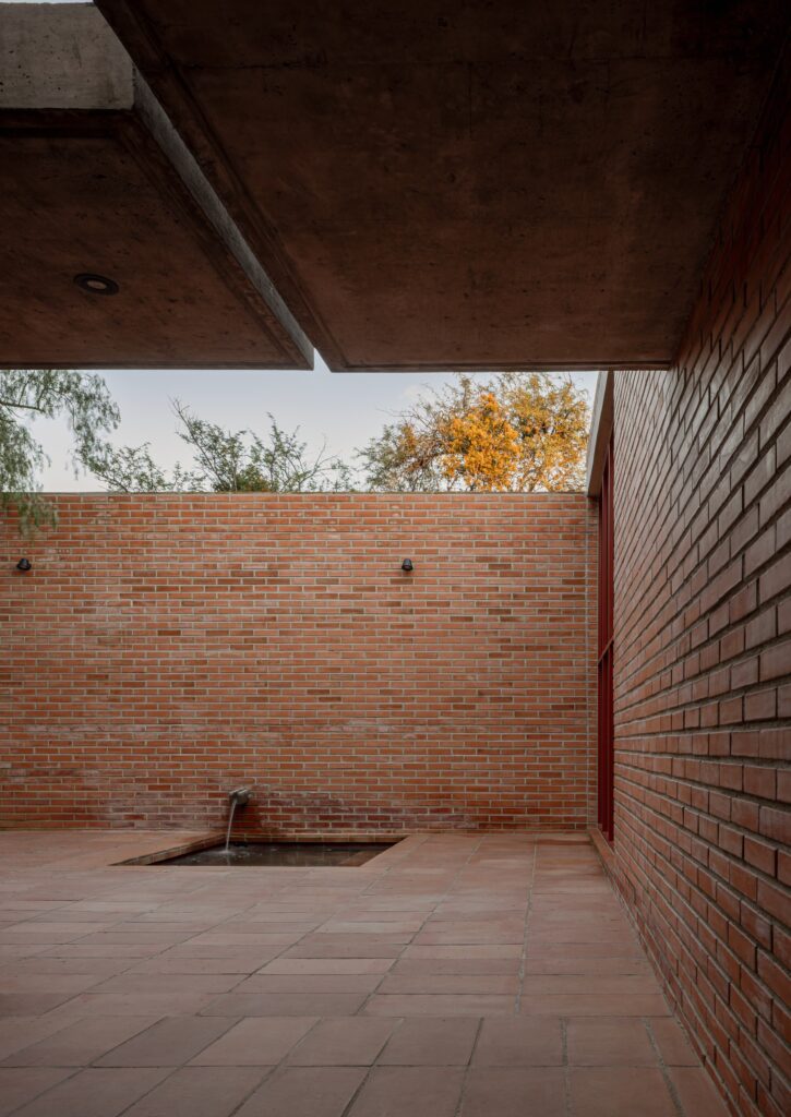 Peroles House in San Miguel de Allende integrates steep terrain, diverse local vegetation, traditional urban planning, and brick construction, showcasing sustainable residential architecture and careful spatial organization.