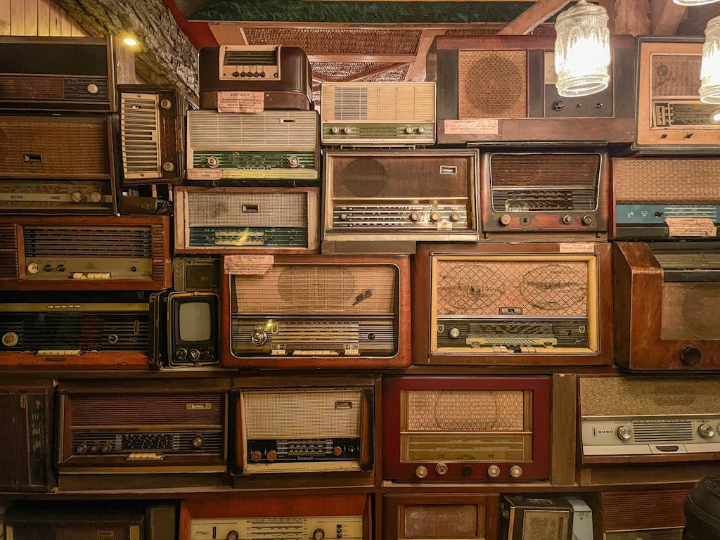 Wall display of vintage radios and a TV in a cozy indoor setting.