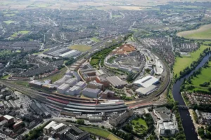 Aerial view of the York Central regeneration site in northern England, showing proposed buildings, green corridors, and adjacent railway infrastructure.