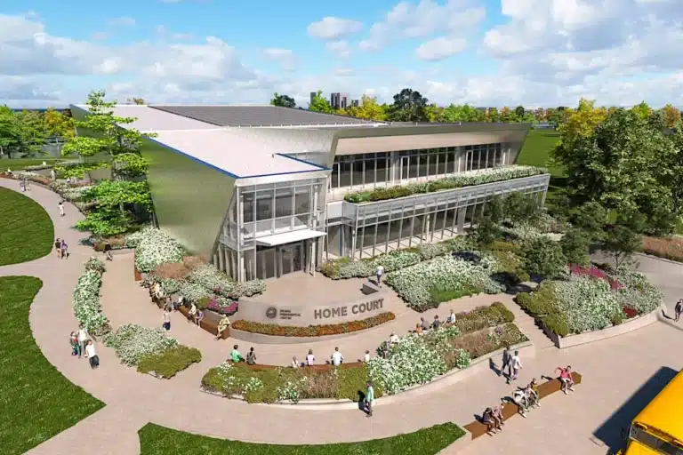 Obama Presidential Center rendering showing the Home Court entrance, surrounded by landscaped pathways and greenery under a clear sky.