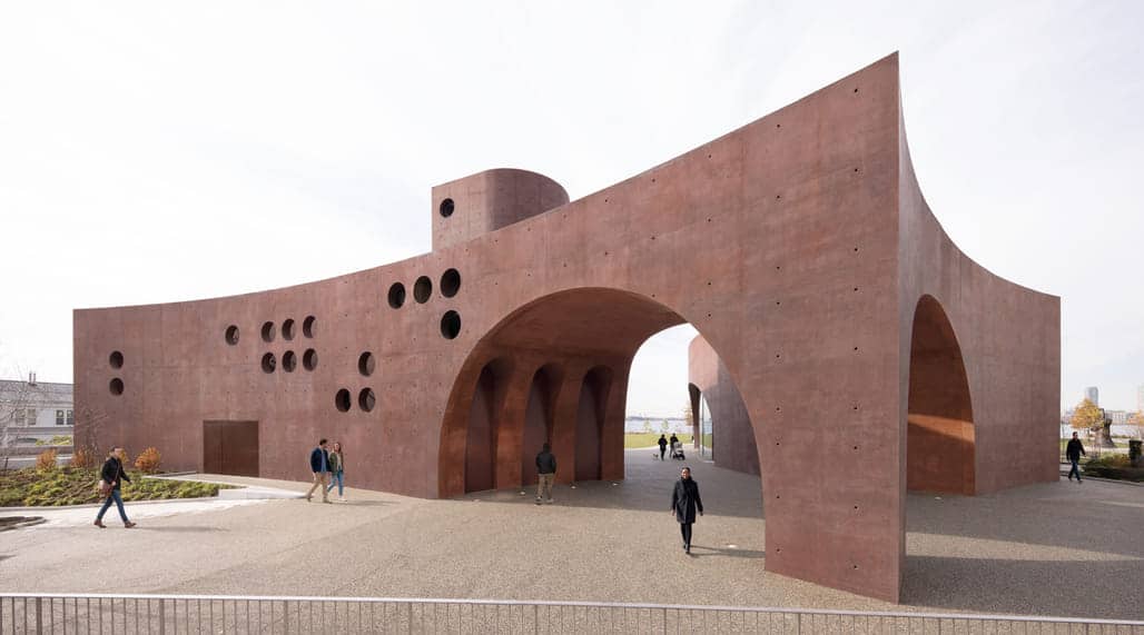 Wagner Park Pavilion in Lower Manhattan, a flood-resilient architectural landmark featuring rust-colored concrete arches and circular openings, integrating public access with coastal infrastructure.