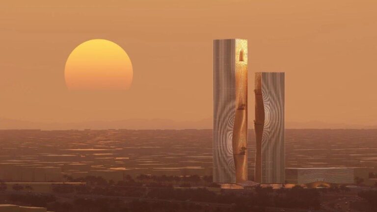 Twin-tower mixed-use skyscraper in North Riyadh at sunset, showcasing vertical facades with golden cladding and sculptural cutouts against the desert skyline.