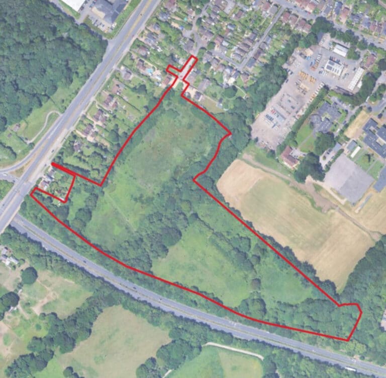 Aerial view of Durley Farm site near Totton, Hampshire, outlined in red, showing green fields bordered by roads and residential areas an example of urban expansion into rural land.