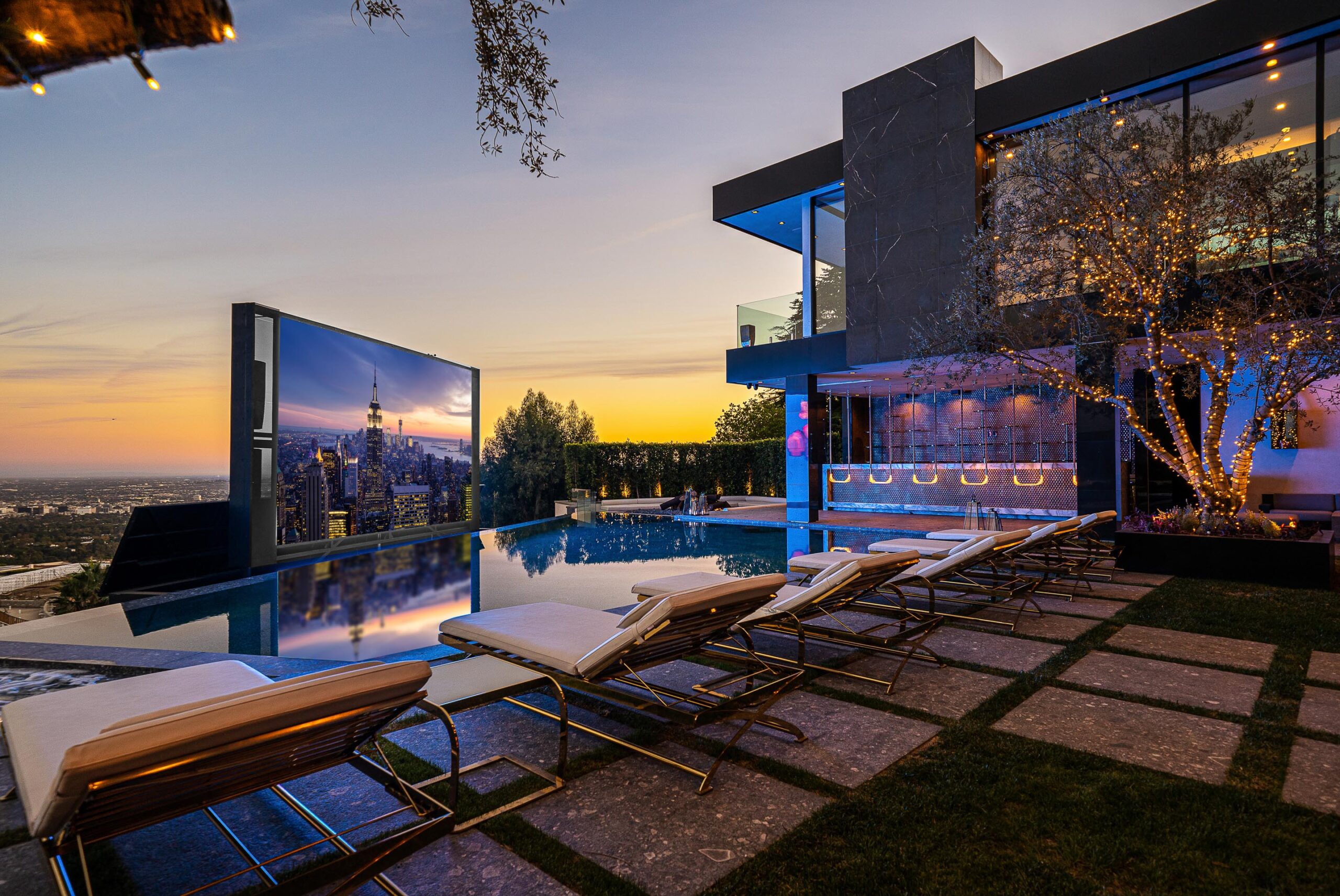 The modern exterior of La Fin Palace in Bel Air at dusk, featuring its illuminated infinity pool and architectural lighting.