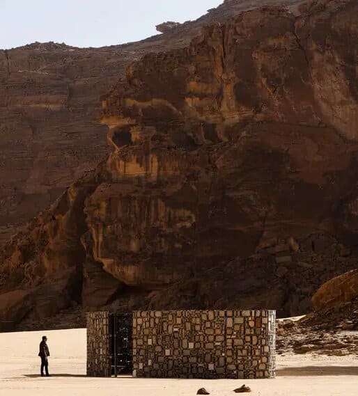 A mirrored, multifaceted structure reflecting the desert landscape at Desert X AlUla, an example of land art blending with nature.