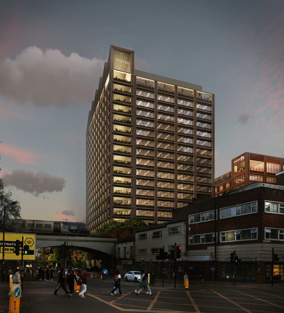 Modern high-rise commercial building at dusk in Manchester’s Sister District, featuring illuminated floors and green terraces, with pedestrians crossing below — a key example of urban expansion integrating architecture and public life.