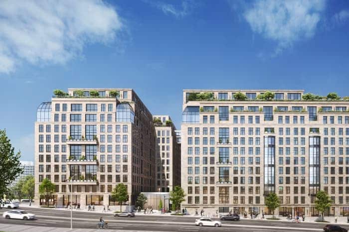 Office-to-residential conversion in downtown Washington: modern multi-story buildings with green roofs, large windows, and street-level pedestrian activity under a clear blue sky.