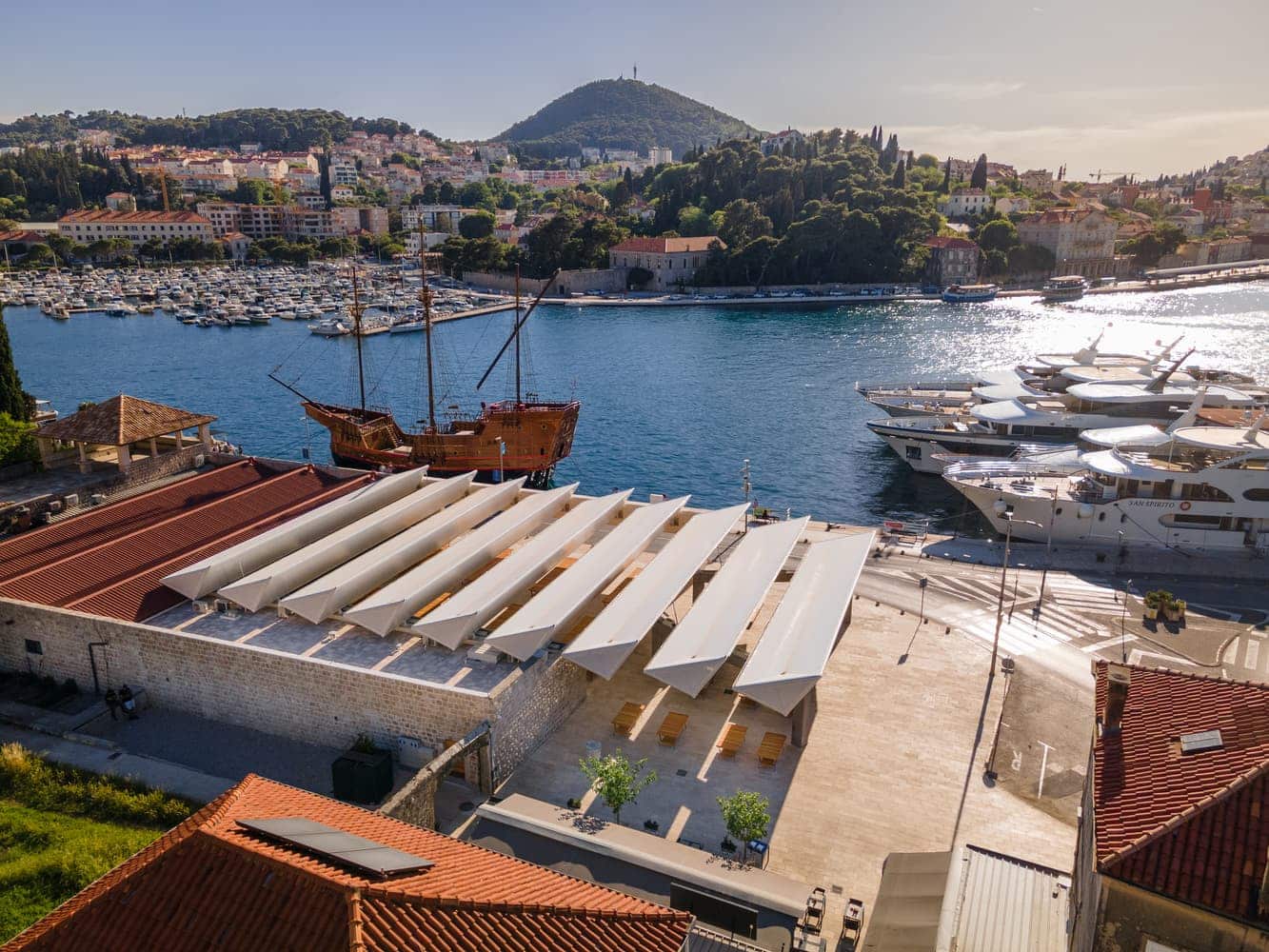 2026 European architecture competition shortlisted project: Gruž Market in Dubrovnik, Croatia — aerial view showing modern canopy, heritage context, and marina.