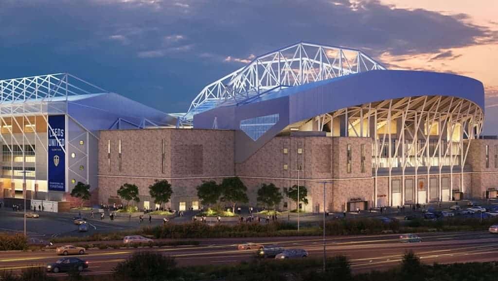 Elland Road expansion rendering showing the stadium’s new upper tier and modern facade under twilight, with traffic and pedestrians in foreground.