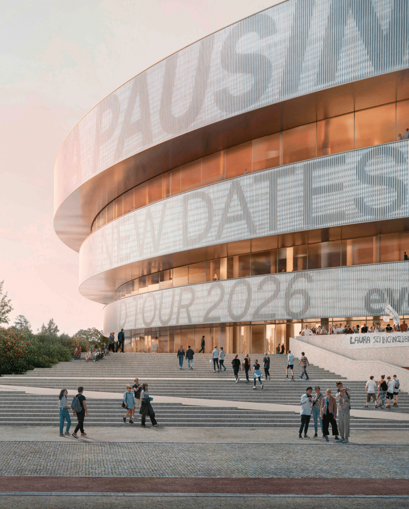 A sweeping view over the large public piazza at the Milano Santa Giulia Arena, with the metallic ringed structure in the background under a clear sky.