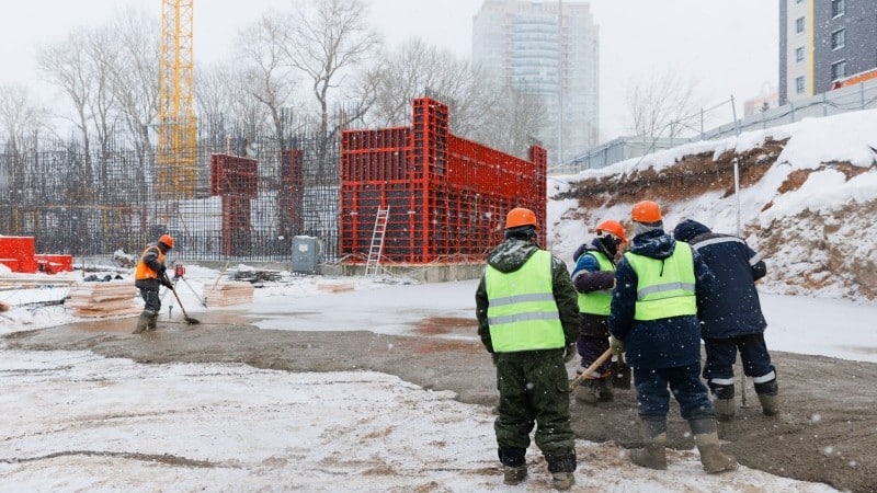 إطلالة بانورامية لأكواخ "الروربور" الحمراء التقليدية في قرية ريني بالنرويج خلال شفق شتوي مثلج، لتوضيح السكون المعماري.