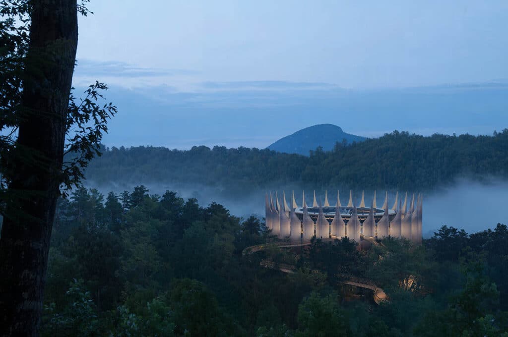 The Lynx futuristic gothic drone stations nestled in a misty mountain forest, showcasing its illuminated crown-like structure at twilight.
