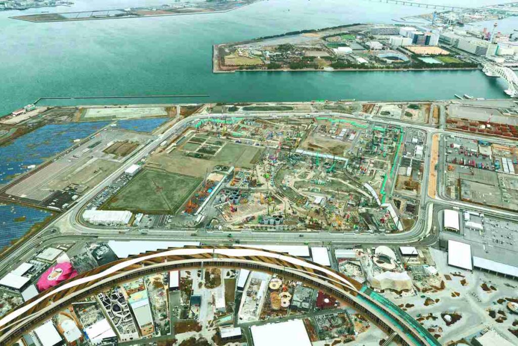 عرض جوي لموقع بناء منتجع كازينو متكامل في أوساكا على جزيرة يوميشيما، يُظهر الأعمال الأولية والبنية التحتية لدعم التوسع الحضري.