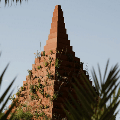 زوار يسيرون عبر عمل فني وردي اللون نابض بالحياة داخل الوديان في معرض ديزرت إكس العلا