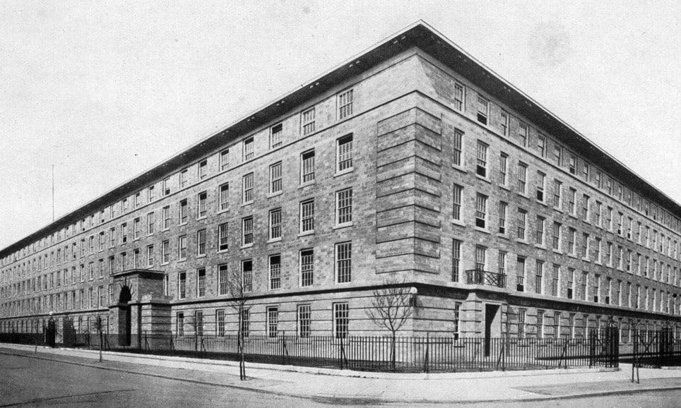 A historic black-and-white photograph of a large, symmetrical brick building with barred windows and a stone base, likely used for institutional or administrative purposes during wartime.