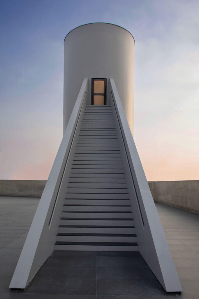 سلالم بيضاء بسيطة تؤدي إلى مدخل برج أسطواني في متحف فن بانكوك