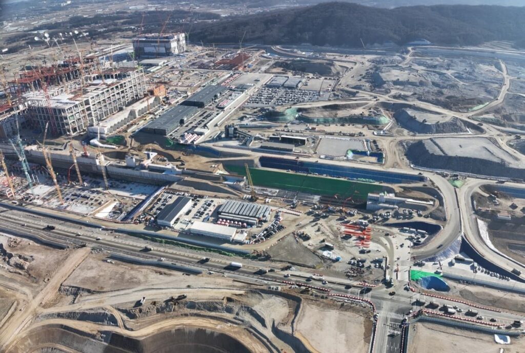 Aerial view of Korea&rsquo;s largest semiconductor complex under construction in Yongin, showing massive excavation, structural frameworks, and surrounding infrastructure.