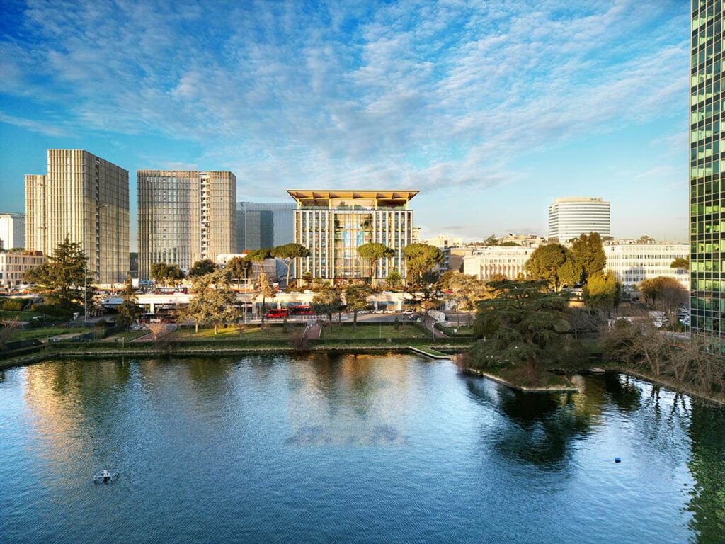 مقر روما البيئي كما يُرى من عبر بحيرة، يبرز سقفه الخشبي وواجهته الزجاجية ضمن خط أفق حي EUR الحديث