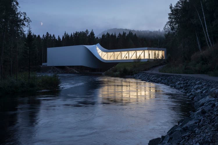 Architectural sustainability in form &mdash; The Twist at Kistefos Museum, Norway, illuminated at dusk, bridges river and forest with its sculptural white volume.