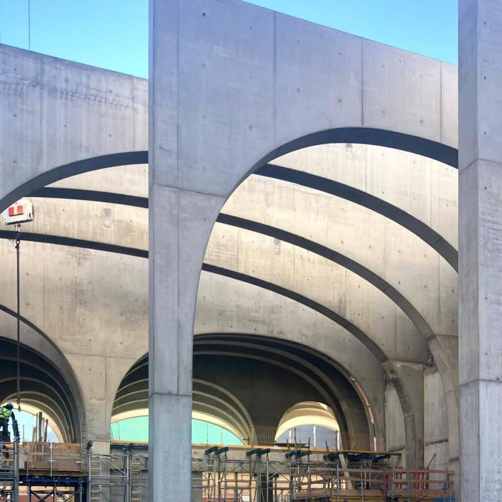 Close-up of concrete arches with dark banding at San Pellegrino Future Factory under construction, Brembo Valley, Italy