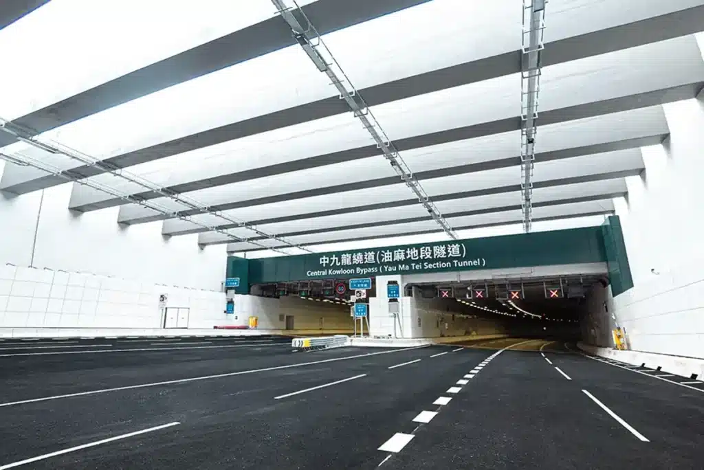 Entrance to the Central Kowloon Bypass (Yau Ma Tei Section Tunnel) in Hong Kong, showing structural ceiling beams, bilingual signage, and multi-lane road surface.