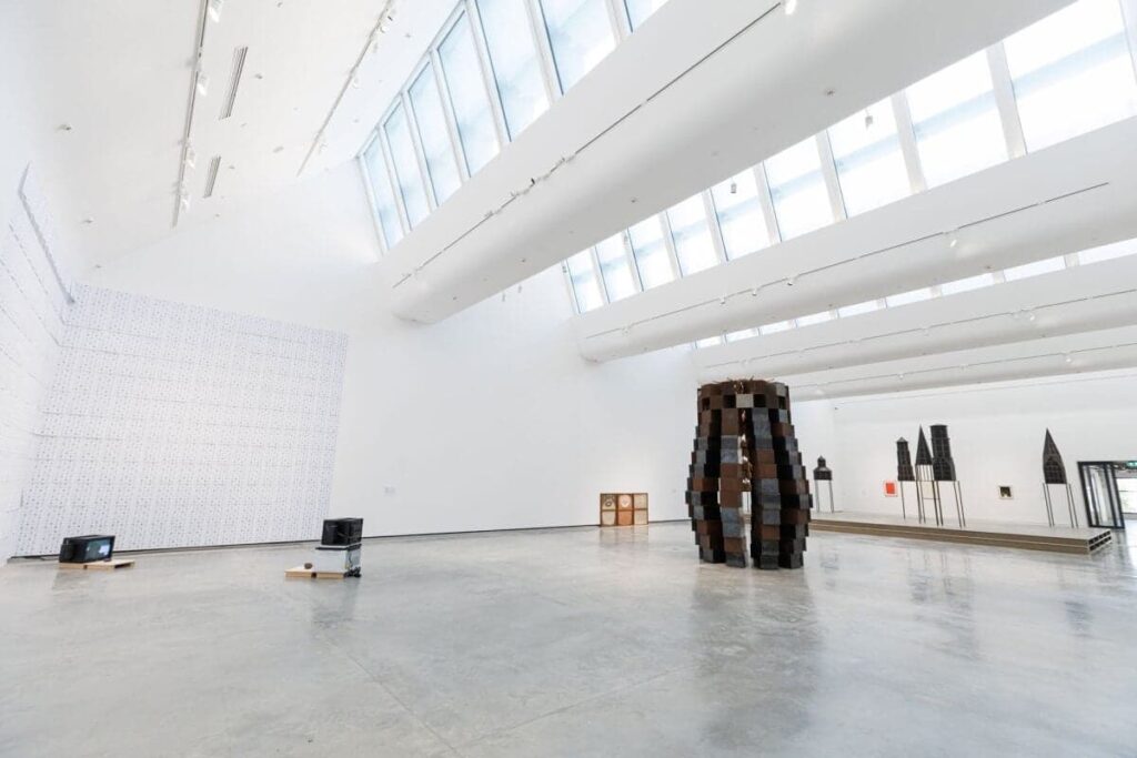 قاعة عرض بيضاء فسيحة مع سقوف زجاجية وتركيبات مختلطة