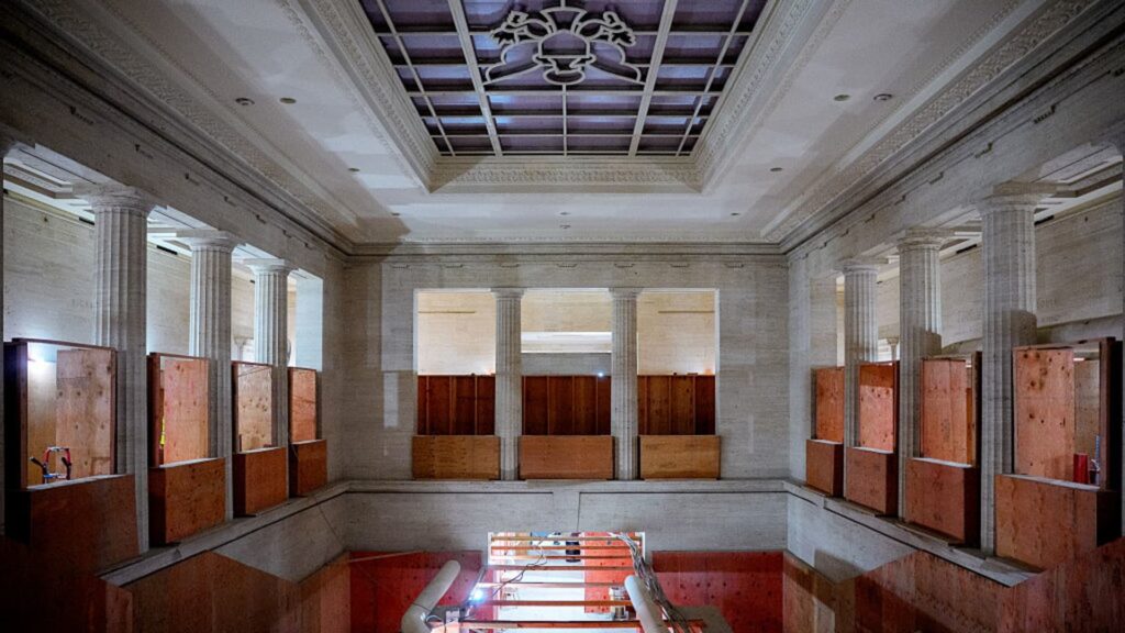 Interior view of the Eccles Building during 2026 renovation, showing exposed structural columns and boarded-up openings within a neoclassical hall &mdash; illustrating phased construction within a protected federal landmark.