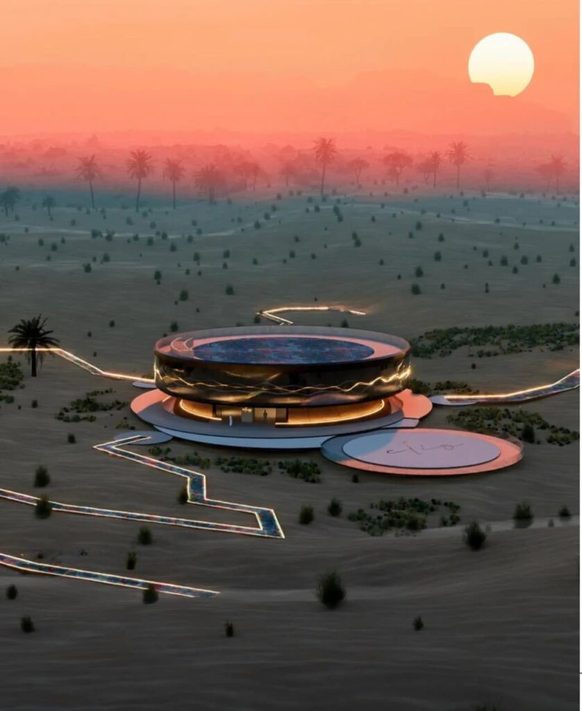 Aerial view of Clio House at sunset: circular desert art pavilion with illuminated pathways radiating across Dubai&rsquo;s Margham Desert under a dramatic orange sky.