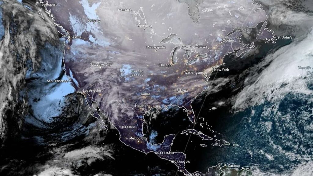 Ice-covered power lines against a dark, stormy sky, symbolizing the failure of the energy grid during the 2026 US winter storm.