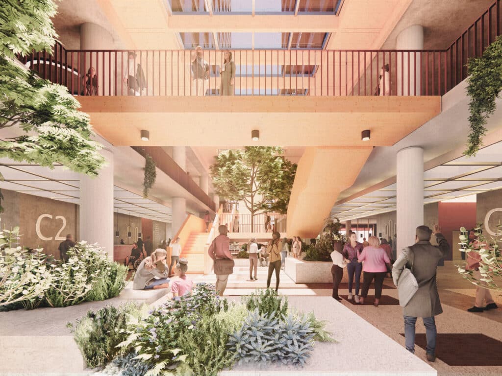 Multi-level atrium inside Plot C&rsquo;s C2 building, featuring natural light, indoor greenery, and people interacting across floors  designed for connectivity and well-being.