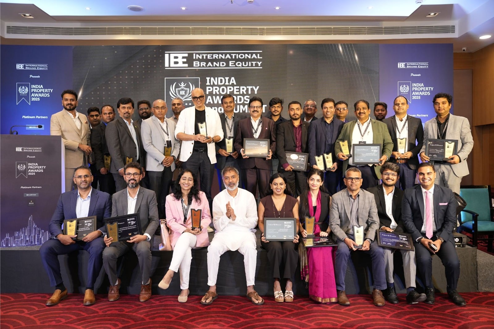 Promotional image for India Property Awards & Summit 2026 showing event branding with award graphics and summit title text.