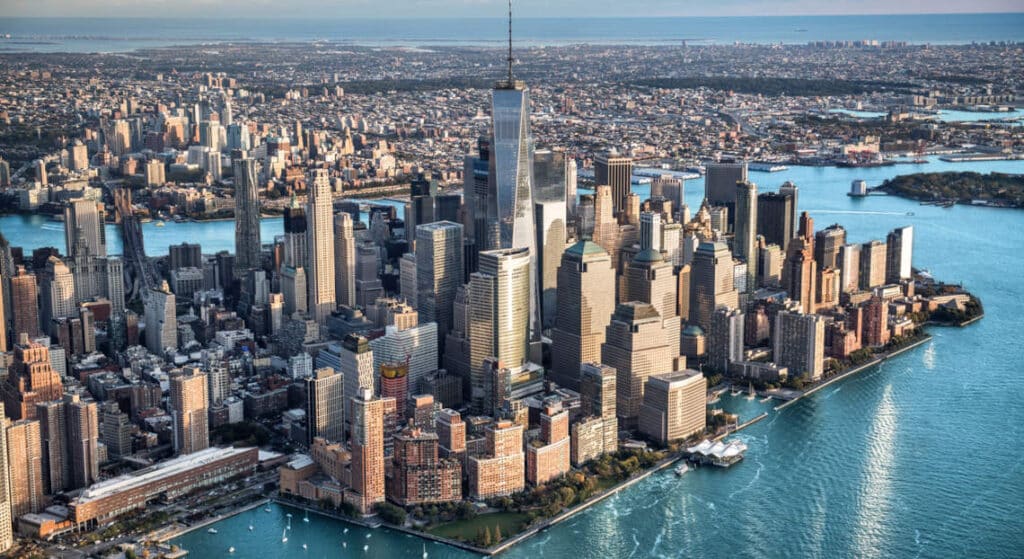 Aerial view of Lower Manhattan skyline at golden hour, showing One World Trade Center and surrounding urban fabric under Architectural Security policy.