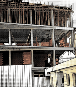 Exterior view of a multi-story building under construction, featuring a reinforced concrete frame, red hollow brick infill walls, and wooden formwork supporting the upper level.