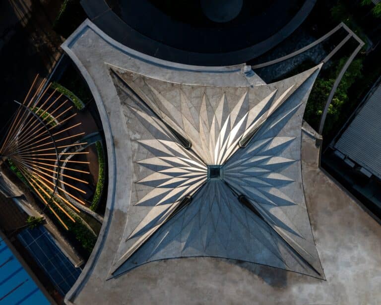 A top-down aerial view of the origami-inspired steel roof of Urban Sparkle restaurant in Ho Chi Minh City, showing geometric folds and skylights.